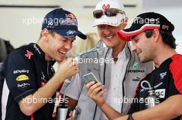 (L to R): Sebastian Vettel (GER) Red Bull Racing, Michael Schumacher (GER) Mercedes AMG F1 and Timo Glock (GER) Marussia F1 Team enjoy something on a mobile phone. 28.10.2012. Formula 1 World Championship, Rd 17, Indian Grand Prix, New Delhi, India, Race Day.