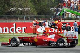 Fernando Alonso (ESP) Ferrari F2012 waves to the fans at the end of the race as he passes the Red Bull Racing RB8 of race retiree Sebastian Vettel (GER) Red Bull Racing. 09.09.2012. Formula 1 World Championship, Rd 13, Italian Grand Prix, Monza, Italy, Race Day