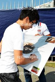 Kamui Kobayashi (JPN) Sauber signs autographs for the fans. 06.09.2012. Formula 1 World Championship, Rd 13, Italian Grand Prix, Monza, Italy, Preparation Day