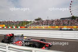 Lewis Hamilton (GBR) McLaren MP4/27 enters the pits as Nico Rosberg (GER) Mercedes AMG F1 W03 passes on track. 06.10.2012. Formula 1 World Championship, Rd 15, Japanese Grand Prix, Suzuka, Japan, Qualifying Day.