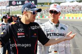 (L to R): Sebastian Vettel (GER) Red Bull Racing with Michael Schumacher (GER) Mercedes AMG F1 on the drivers parade. 07.10.2012. Formula 1 World Championship, Rd 15, Japanese Grand Prix, Suzuka, Japan, Race Day.