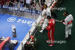 Race winner Fernando Alonso (ESP) Ferrari celebrates with the champagne with third placed Lewis Hamilton (GBR) McLaren and second placed Sergio Perez (MEX) Sauber on the podium. 25.03.2012. Formula 1 World Championship, Rd 2, Malaysian Grand Prix, Sepang, Malaysia, Sunday Podium