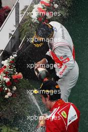 Race winner Fernando Alonso (ESP) Ferrari celebrates with the champagne with third placed Lewis Hamilton (GBR) McLaren on the podium. 25.03.2012. Formula 1 World Championship, Rd 2, Malaysian Grand Prix, Sepang, Malaysia, Sunday Podium
