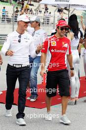 (L to R): Michael Schumacher (GER) Mercedes AMG F1 with Fernando Alonso (ESP) Ferrari on the drivers parade. 25.03.2012. Formula 1 World Championship, Rd 2, Malaysian Grand Prix, Sepang, Malaysia, Sunday