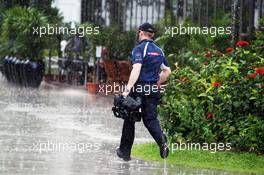 A Sky Sports F1 Cameraman gets caught in the rain in the paddock. 22.03.2012. Formula 1 World Championship, Rd 2, Malaysian Grand Prix, Sepang, Malaysia, Thursday