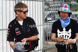 Sebastian Vettel (GER) Red Bull Racing with a fan. 22.03.2012. Formula 1 World Championship, Rd 2, Malaysian Grand Prix, Sepang, Malaysia, Thursday