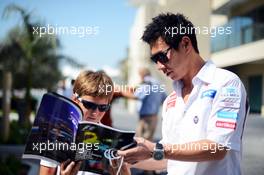 Kamui Kobayashi (JPN) Sauber signs autographs for the fans. 02.11.2012. Formula 1 World Championship, Rd 18, Abu Dhabi Grand Prix, Yas Marina Circuit, Abu Dhabi, Practice Day.