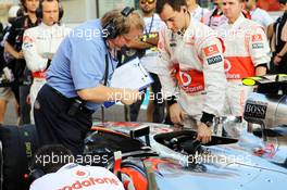 Jo Baue, FIA, looks at the McLaren MP4/27 of Lewis Hamilton (GBR) McLaren on the grid. 04.11.2012. Formula 1 World Championship, Rd 18, Abu Dhabi Grand Prix, Yas Marina Circuit, Abu Dhabi, Race Day.