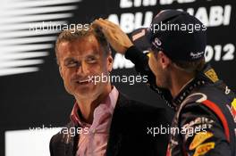 David Coulthard (GBR) Red Bull Racing and Scuderia Toro Advisor / BBC Television Commentator with Sebastian Vettel (GER) Red Bull Racing on the podium. 04.11.2012. Formula 1 World Championship, Rd 18, Abu Dhabi Grand Prix, Yas Marina Circuit, Abu Dhabi, Race Day.