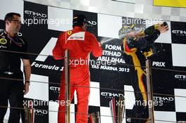Fernando Alonso (ESP) Ferrari and race winner Kimi Raikkonen (FIN) Lotus F1 Team celebrate on the podium. 04.11.2012. Formula 1 World Championship, Rd 18, Abu Dhabi Grand Prix, Yas Marina Circuit, Abu Dhabi, Race Day.