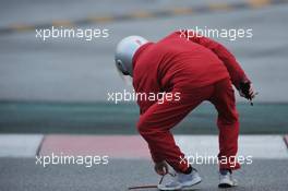 A marshal removes debris from the track. 01.03.2013. Formula One Testing, Day Two, Barcelona, Spain.