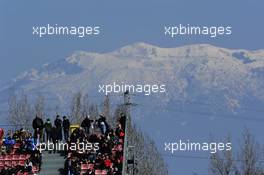 Fans in the grandstand with snow on the mountains. 02.03.2013. Formula One Testing, Day Three, Barcelona, Spain.