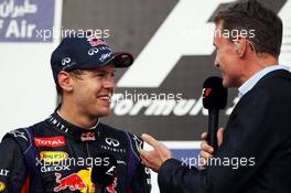 Race winner Sebastian Vettel (GER) Red Bull Racing on the podium with David Coulthard (GBR) Red Bull Racing and Scuderia Toro Advisor / BBC Television Commentator. 21.04.2013. Formula 1 World Championship, Rd 4, Bahrain Grand Prix, Sakhir, Bahrain, Race Day
