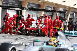 Felipe Massa (BRA) Ferrari F138 makes a pit stop as Lewis Hamilton (GBR) Mercedes AMG F1 W04 passes. 21.04.2013. Formula 1 World Championship, Rd 4, Bahrain Grand Prix, Sakhir, Bahrain, Race Day