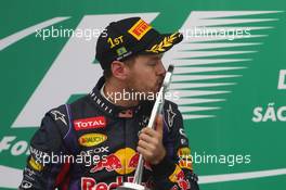 Race winner Sebastian Vettel (GER) Red Bull Racing celebrates on the podium. 24.11.2013. Formula 1 World Championship, Rd 19, Brazilian Grand Prix, Sao Paulo, Brazil, Race Day.