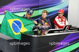 Mark Webber (AUS) Red Bull Racing, celebrating his final GP, holds a brazilian flag, signed by Bernie Ecclestone (GBR) CEO Formula One Group (FOM) and all the drivers, alongside Sebastian Vettel (GER) Red Bull Racing (Centre), and Fernando Alonso (ESP) Ferrari, (Right). 24.11.2013. Formula 1 World Championship, Rd 19, Brazilian Grand Prix, Sao Paulo, Brazil, Race Day.