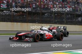 Jenson Button (GBR) McLaren MP4-28 and Nico Hulkenberg (GER) Sauber C32 battle for position. 24.11.2013. Formula 1 World Championship, Rd 19, Brazilian Grand Prix, Sao Paulo, Brazil, Race Day.