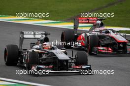 (L to R): Nico Hulkenberg (GER) Sauber C32 and Jenson Button (GBR) McLaren MP4-28 battle for position. 24.11.2013. Formula 1 World Championship, Rd 19, Brazilian Grand Prix, Sao Paulo, Brazil, Race Day.