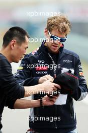 Sebastian Vettel (GER) Red Bull Racing signs autographs for the fans. 11.04.2013. Formula 1 World Championship, Rd 3, Chinese Grand Prix, Shanghai, China, Preparation Day.