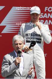Race winner Nico Rosberg (GER) Mercedes AMG F1 with Damon Hill (GBR) Sky Sports Presenter on the podium. 30.06.2013. Formula 1 World Championship, Rd 8, British Grand Prix, Silverstone, England, Race Day.
