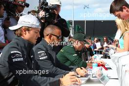 (L to R): Nico Rosberg (GER) Mercedes AMG F1 and team mate Lewis Hamilton (GBR) Mercedes AMG F1 sign autographs for the fans. 29.06.2013. Formula 1 World Championship, Rd 8, British Grand Prix, Silverstone, England, Qualifying Day.