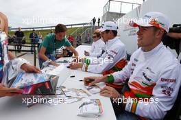 Paul di Resta (GBR) Sahara Force India F1 and team mate Adrian Sutil (GER) Sahara Force India F1 sign autographs for the fans. 29.06.2013. Formula 1 World Championship, Rd 8, British Grand Prix, Silverstone, England, Qualifying Day.