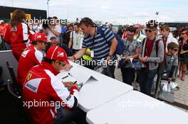 (L to R): Fernando Alonso (ESP) Ferrari and team mate Felipe Massa (BRA) Ferrari sign autographs for the fans. 29.06.2013. Formula 1 World Championship, Rd 8, British Grand Prix, Silverstone, England, Qualifying Day.
