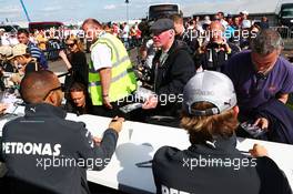 (L to R): Lewis Hamilton (GBR) Mercedes AMG F1 and team mate Nico Rosberg (GER) Mercedes AMG F1 sign autographs for the fans. 29.06.2013. Formula 1 World Championship, Rd 8, British Grand Prix, Silverstone, England, Qualifying Day.