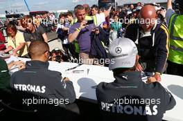 (L to R): Lewis Hamilton (GBR) Mercedes AMG F1 and team mate Nico Rosberg (GER) Mercedes AMG F1 sign autographs for the fans. 29.06.2013. Formula 1 World Championship, Rd 8, British Grand Prix, Silverstone, England, Qualifying Day.