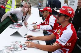 Fernando Alonso (ESP) Ferrari and Felipe Massa (BRA) Ferrari sign autographs for the fans. 29.06.2013. Formula 1 World Championship, Rd 8, British Grand Prix, Silverstone, England, Qualifying Day.