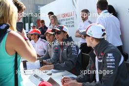 Nico Hulkenberg (GER) Sauber (Right) and team mate Esteban Gutierrez (MEX) Sauber, with Sergio Perez (MEX) McLaren (Left), sign autographs for the fans. 29.06.2013. Formula 1 World Championship, Rd 8, British Grand Prix, Silverstone, England, Qualifying Day.