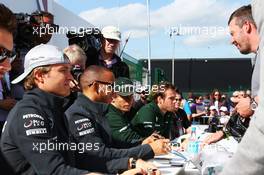 Nico Rosberg (GER) Mercedes AMG F1 and team mate Lewis Hamilton (GBR) Mercedes AMG F1 sign autographs for the fans. 29.06.2013. Formula 1 World Championship, Rd 8, British Grand Prix, Silverstone, England, Qualifying Day.