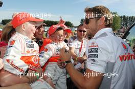 Jenson Button (GBR) McLaren with young fans. 30.06.2013. Formula 1 World Championship, Rd 8, British Grand Prix, Silverstone, England, Race Day.