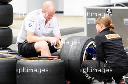 McLaren mechanic with a Pirelli Tyre Engineer. 27.06.2013. Formula 1 World Championship, Rd 8, British Grand Prix, Silverstone, England, Preparation Day.