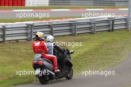 Fernando Alonso (ESP) Ferrari heads back to the pits on a scooter after he stopped in the first practice session. 05.07.2013. Formula 1 World Championship, Rd 9, German Grand Prix, Nurburgring, Germany, Practice Day.