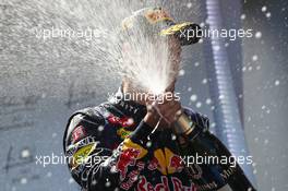 Race winner Sebastian Vettel (GER) Red Bull Racing RB9 celebrates with the champagne on the podium. 07.07.2013. Formula 1 World Championship, Rd 9, German Grand Prix, Nurburgring, Germany, Race Day.