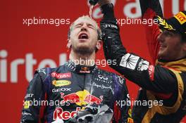 Race winner and World Champion Sebastian Vettel (GER) Red Bull Racing celebrates on the podium with third placed Romain Grosjean (FRA) Lotus F1 Team. 27.10.2013. Formula 1 World Championship, Rd 16, Indian Grand Prix, New Delhi, India, Race Day.