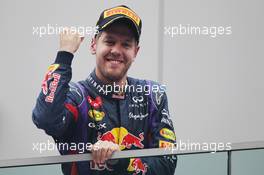 Race winner and World Champion Sebastian Vettel (GER) Red Bull Racing celebrates on the podium. 27.10.2013. Formula 1 World Championship, Rd 16, Indian Grand Prix, New Delhi, India, Race Day.