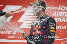 Race winner and World Champion Sebastian Vettel (GER) Red Bull Racing celebrates with the champagne on the podium. 27.10.2013. Formula 1 World Championship, Rd 16, Indian Grand Prix, New Delhi, India, Race Day.