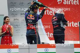 Race winner and World Champion Sebastian Vettel (GER) Red Bull Racing celebrates with the champagne on the podium with Adrian Newey (GBR) Red Bull Racing Chief Technical Officer. 27.10.2013. Formula 1 World Championship, Rd 16, Indian Grand Prix, New Delhi, India, Race Day.
