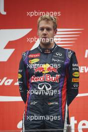 Race winner and World Champion Sebastian Vettel (GER) Red Bull Racing on the podium. 27.10.2013. Formula 1 World Championship, Rd 16, Indian Grand Prix, New Delhi, India, Race Day.