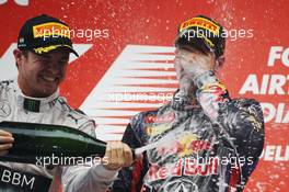 Race winner and World Champion Sebastian Vettel (GER) Red Bull Racing celebrates on the podium with Nico Rosberg (GER) Mercedes AMG F1. 27.10.2013. Formula 1 World Championship, Rd 16, Indian Grand Prix, New Delhi, India, Race Day.
