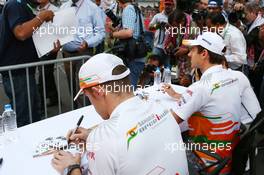 (L to R): Paul di Resta (GBR) Sahara Force India F1 and team mate Adrian Sutil (GER) Sahara Force India F1 sign autographs for the fans. 24.10.2013. Formula 1 World Championship, Rd 16, Indian Grand Prix, New Delhi, India, Preparation Day.