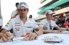 Adrian Sutil (GER) Sahara Force India F1 and Paul di Resta (GBR) Sahara Force India F1 sign autographs for the fans. 24.10.2013. Formula 1 World Championship, Rd 16, Indian Grand Prix, New Delhi, India, Preparation Day.