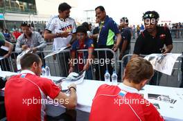 (L to R): Jules Bianchi (FRA) Marussia F1 Team and team mate Max Chilton (GBR) Marussia F1 Team sign autographs for the fans. 24.10.2013. Formula 1 World Championship, Rd 16, Indian Grand Prix, New Delhi, India, Preparation Day.