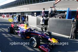 The McLaren MP4-28 of Jenson Button (GBR) McLaren returns back to the pits on the back of a truck and is passed by Mark Webber (AUS) Red Bull Racing RB9. 05.02.2013. Formula One Testing, Day One, Jerez, Spain.