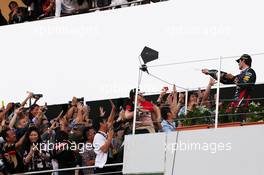 Mark Webber (AUS) Red Bull Racing celebrates his second position with the champagne with fans on the podium. 13.10.2013. Formula 1 World Championship, Rd 15, Japanese Grand Prix, Suzuka, Japan, Race Day.