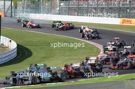 Lewis Hamilton (GBR) Mercedes AMG F1 W04 slows with a puncture after contact at the start of the race with Sebastian Vettel (GER) Red Bull Racing RB9, as Jules Bianchi (FRA) Marussia F1 Team MR02 and Giedo van der Garde (NLD) Caterham CT03 crash in the background. 13.10.2013. Formula 1 World Championship, Rd 15, Japanese Grand Prix, Suzuka, Japan, Race Day.