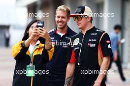 (L to R): Sebastian Vettel (GER) Red Bull Racing and Kimi Raikkonen (FIN) Lotus F1 Team pose for a photo with a fan in the paddock. 05.10.2013. Formula 1 World Championship, Rd 14, Korean Grand Prix, Yeongam, South Korea, Qualifying Day.