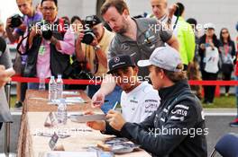 Nico Rosberg (GER) Mercedes AMG F1 W04 and team mate Lewis Hamilton (GBR) Mercedes AMG F1 sign autographs for the fans. 05.10.2013. Formula 1 World Championship, Rd 14, Korean Grand Prix, Yeongam, South Korea, Qualifying Day.